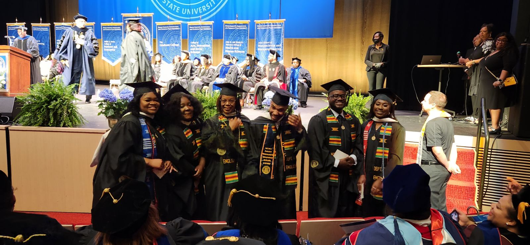 Graduating MA students in cap and gown